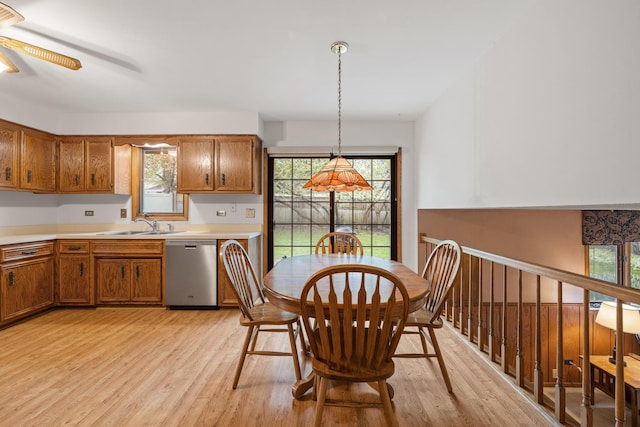 kitchen with a ceiling fan, decorative light fixtures, brown cabinets, dishwasher, and light wood-style floors