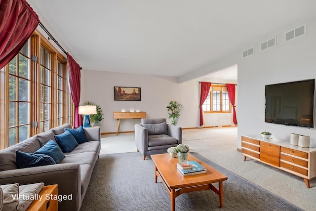 carpeted living area featuring baseboards and visible vents