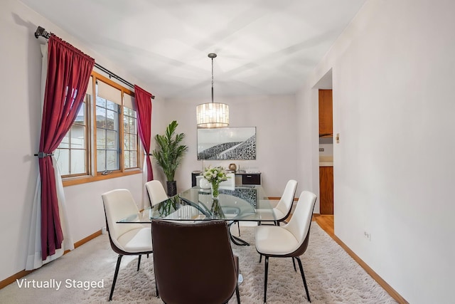 dining room with baseboards, carpet flooring, and an inviting chandelier
