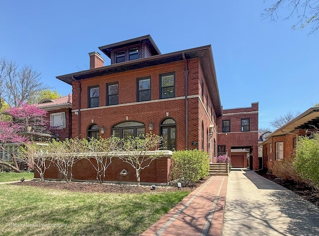 6907 S Constance Ave, Chicago, IL 60649 - view of front of property featuring brick siding, an attached garage, driveway, and a chimney