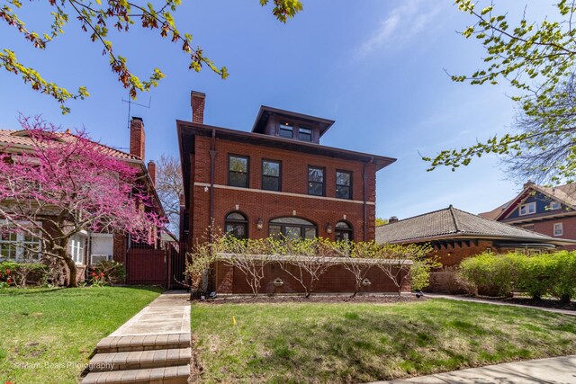 6907 S Constance Ave, Chicago, IL 60649 - view of front facade with brick siding, a chimney, and a front lawn