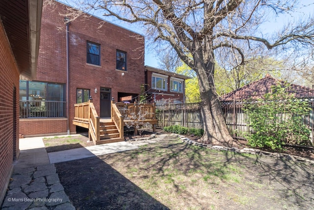 6907 S Constance Ave, Chicago, IL 60649 - rear view of property with fence, a wooden deck, and brick siding