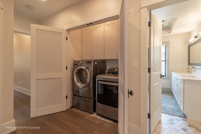 6907 S Constance Ave, Chicago, IL 60649 - washroom featuring a sink, washing machine and dryer, cabinet space, and wood finished floors