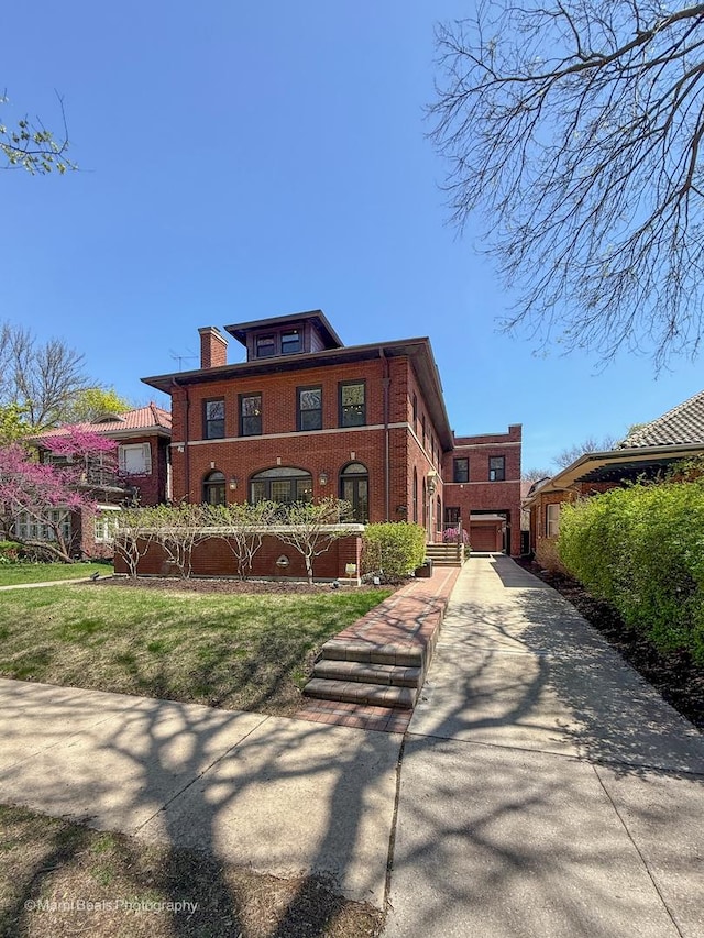 6907 S Constance Ave, Chicago, IL 60649 - view of front facade featuring a front yard, driveway, and brick siding