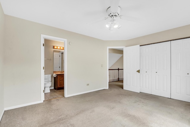 unfurnished bedroom with carpet floors, baseboards, a closet, and connected bathroom