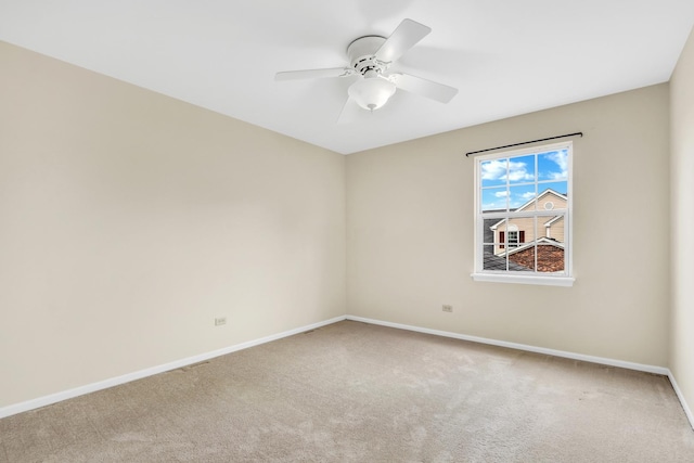 carpeted empty room with baseboards and a ceiling fan