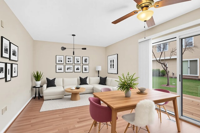 dining room featuring a ceiling fan, baseboards, and light wood-style flooring