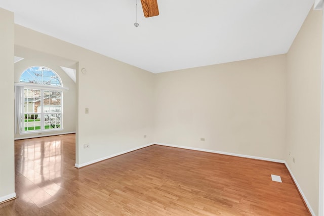 unfurnished room featuring baseboards, a ceiling fan, and light wood-style flooring