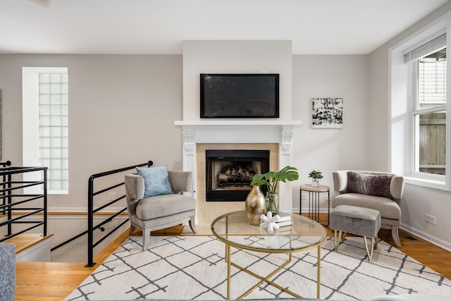 sitting room with light wood-style floors, baseboards, a fireplace, and visible vents