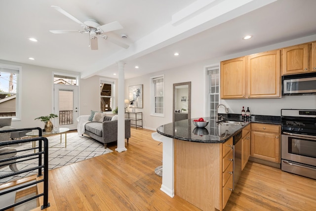 kitchen featuring recessed lighting, appliances with stainless steel finishes, a sink, and light wood-type flooring