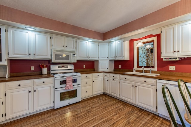 11 N Beech St, Princeton, IL 61356 - kitchen with white appliances, a sink, dark countertops, light wood finished floors, and white cabinets
