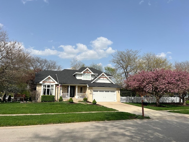 craftsman inspired home featuring a porch, roof with shingles, fence, a front lawn, and concrete driveway