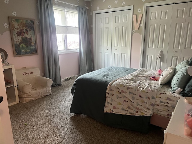 carpeted bedroom with two closets and visible vents