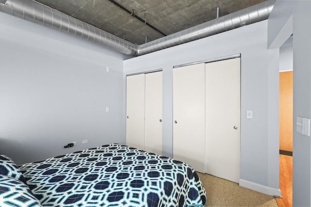bedroom with multiple closets and light colored carpet