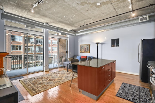 office with light wood finished floors, track lighting, and baseboards