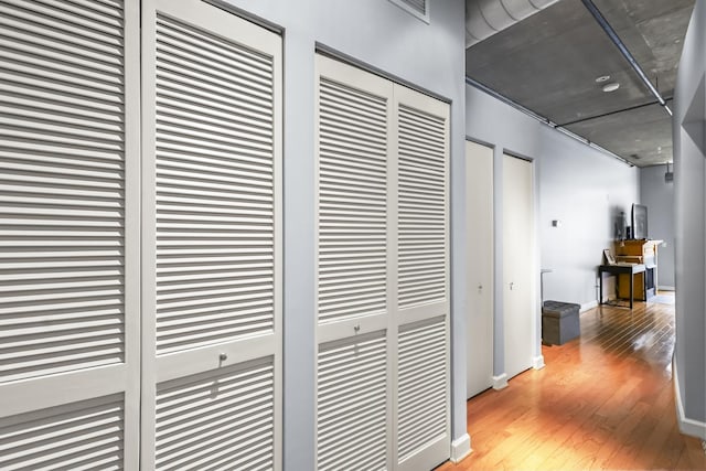 corridor with wood-type flooring and baseboards