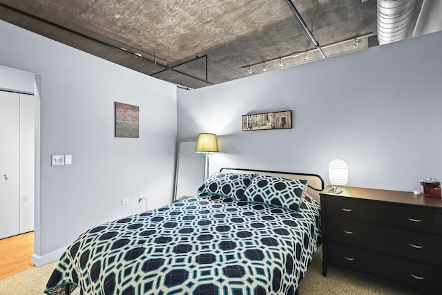 bedroom featuring a closet, baseboards, and wood finished floors