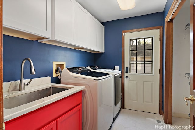 clothes washing area with separate washer and dryer, a sink, cabinet space, and light tile patterned floors