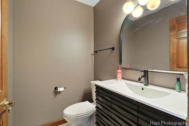 half bathroom featuring vanity and toilet