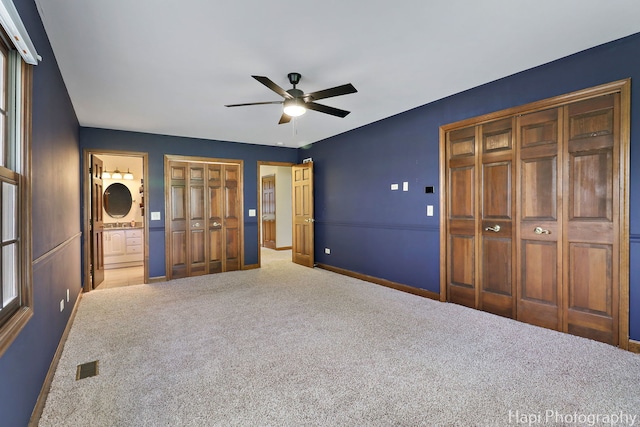 unfurnished bedroom with carpet flooring, baseboards, visible vents, and ensuite bath