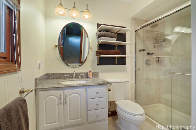 full bathroom featuring vanity, a stall shower, and toilet