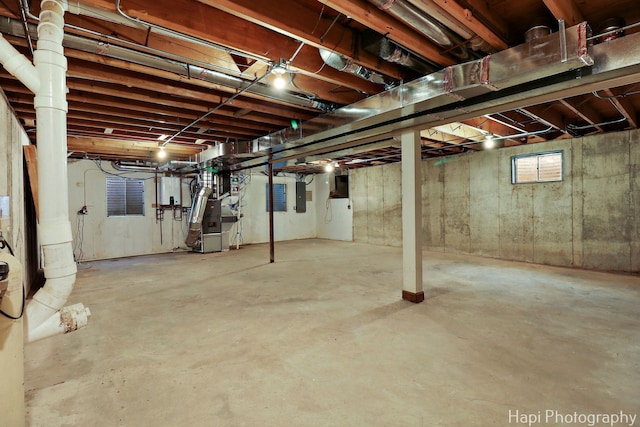 unfinished below grade area with heating unit and electric panel