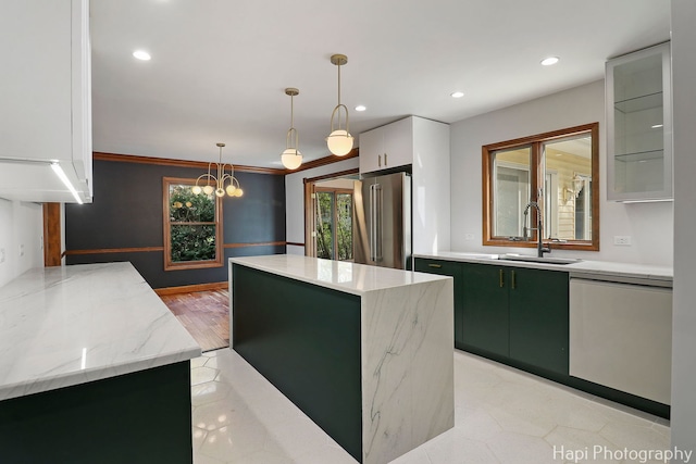 kitchen with a kitchen island, decorative light fixtures, high quality fridge, a sink, and dishwashing machine
