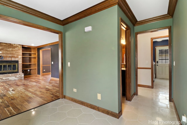 unfurnished living room featuring crown molding, tile patterned flooring, a fireplace, baseboards, and built in shelves
