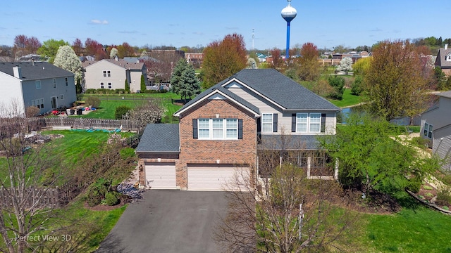 traditional home featuring a garage, aphalt driveway, a front yard, brick siding, and a residential view