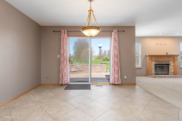 interior space with a brick fireplace, recessed lighting, baseboards, and tile patterned flooring