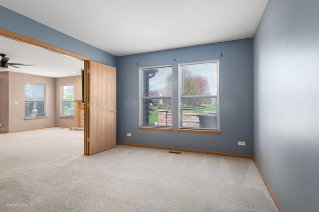 spare room featuring baseboards, ceiling fan, carpet, and visible vents