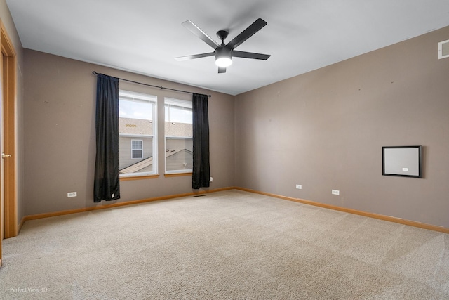 spare room with a ceiling fan, baseboards, light colored carpet, and visible vents