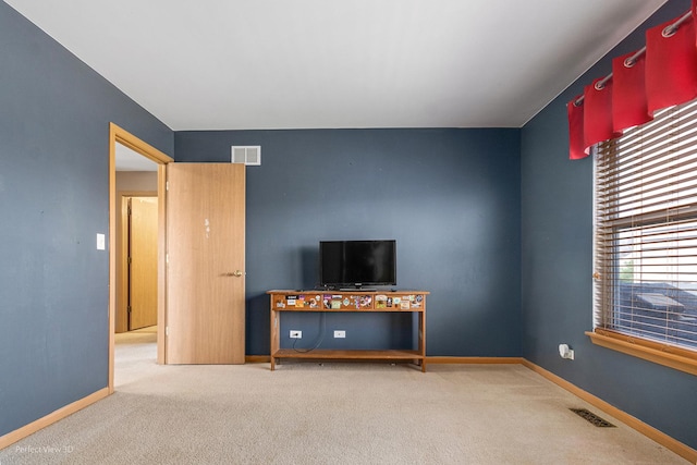 unfurnished living room featuring baseboards, carpet flooring, and visible vents