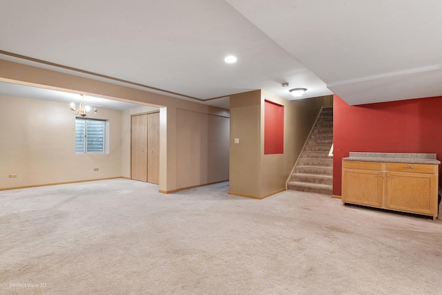 below grade area featuring a chandelier, baseboards, light colored carpet, and stairway