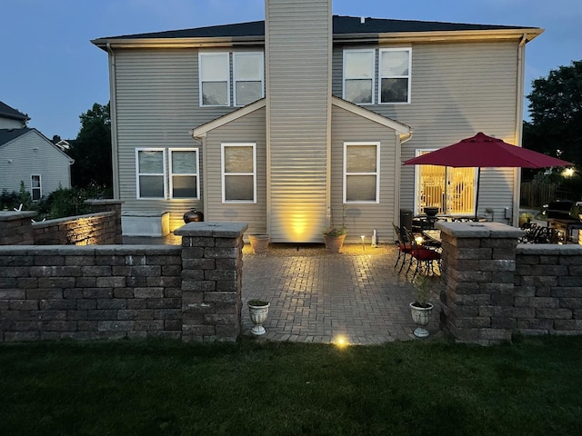 back of property featuring a patio area and a chimney