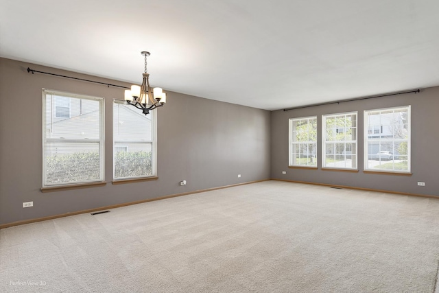 empty room featuring an inviting chandelier, carpet flooring, baseboards, and visible vents