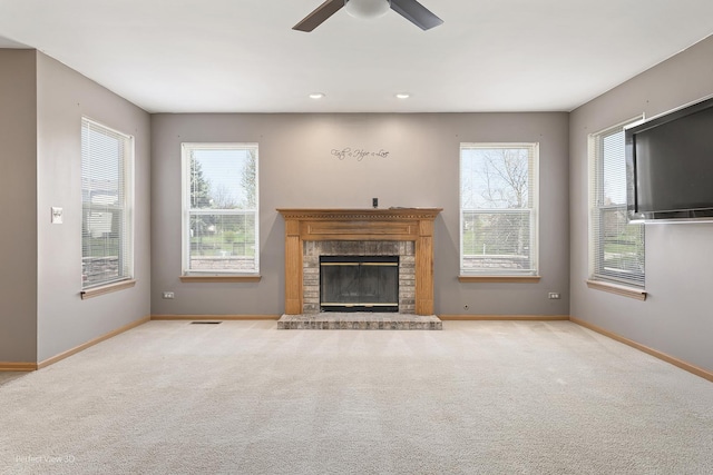 unfurnished living room featuring a ceiling fan, baseboards, a fireplace, and carpet flooring