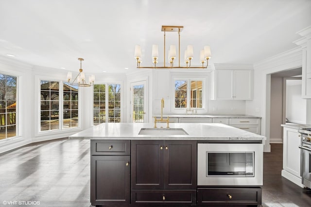 kitchen featuring a sink, a wealth of natural light, stainless steel appliances, and a chandelier
