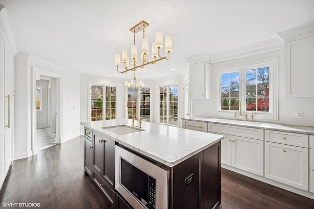 kitchen featuring a chandelier, ornamental molding, and a sink