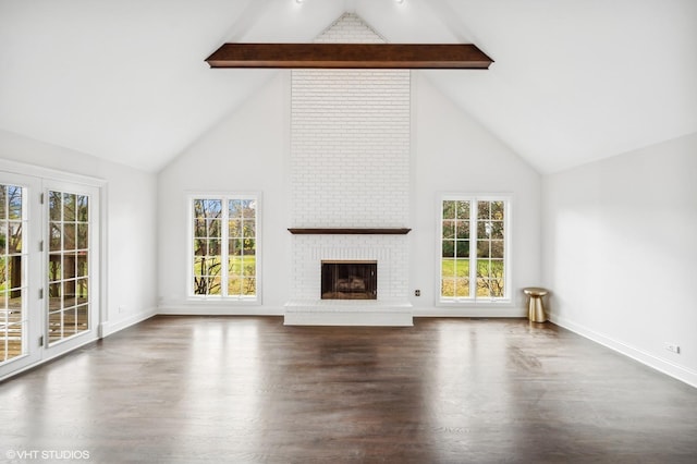 unfurnished living room with a healthy amount of sunlight, high vaulted ceiling, beam ceiling, and wood finished floors