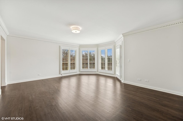 empty room with baseboards, ornamental molding, and dark wood-style floors