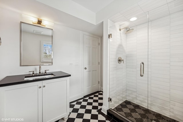 full bathroom featuring tile patterned floors, a shower stall, baseboards, and vanity