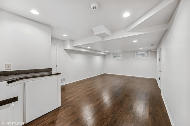 below grade area featuring recessed lighting, dark wood finished floors, and visible vents