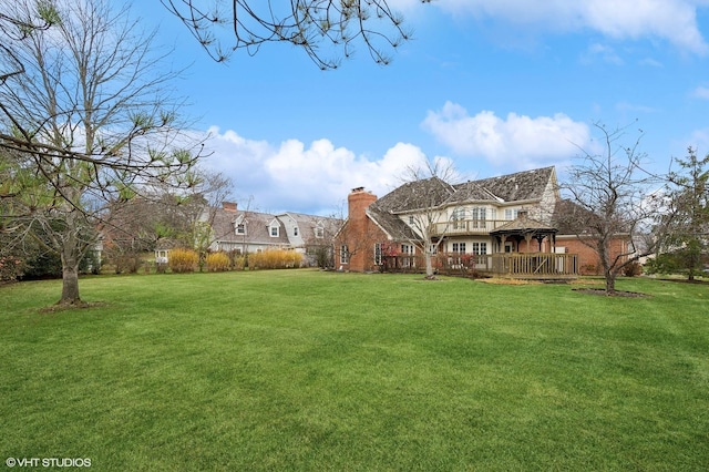 back of house with a lawn, a gazebo, a wooden deck, and a chimney