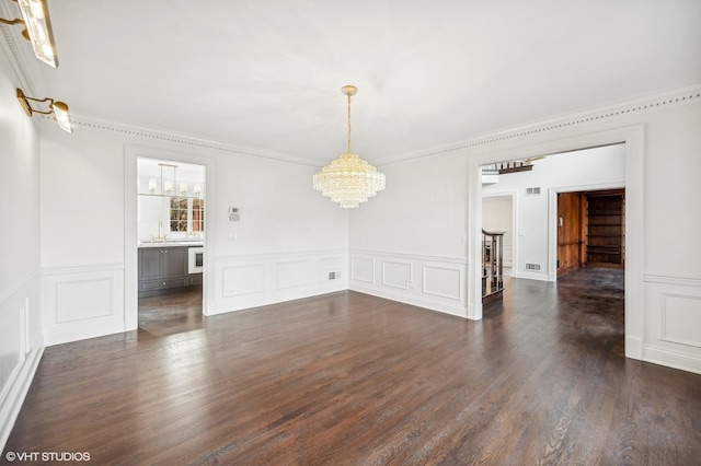 unfurnished dining area with a decorative wall, a chandelier, ornamental molding, visible vents, and dark wood-style floors