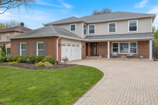 traditional-style home with brick siding, decorative driveway, a front lawn, and an attached garage