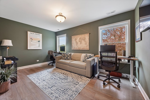 office with baseboards, wood finished floors, and visible vents