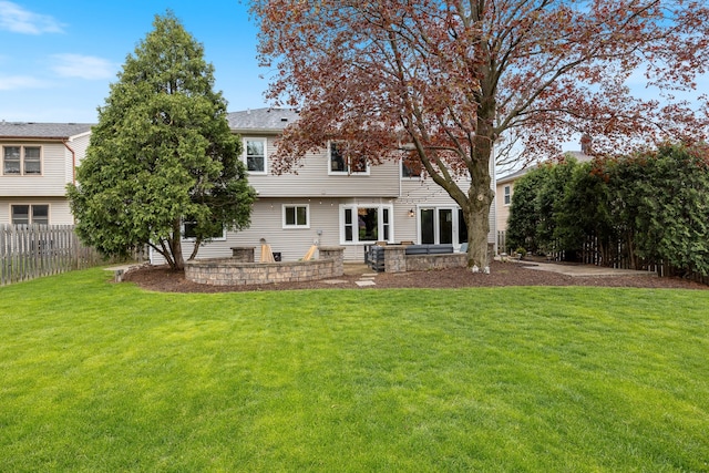 rear view of house with fence and a lawn