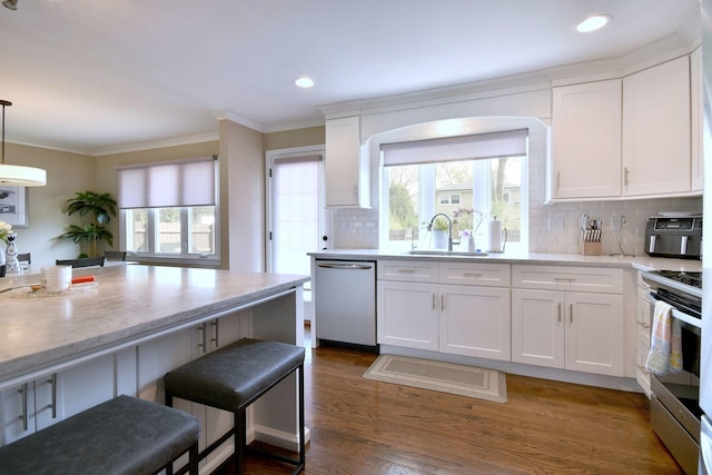 kitchen featuring a sink, appliances with stainless steel finishes, crown molding, and white cabinets