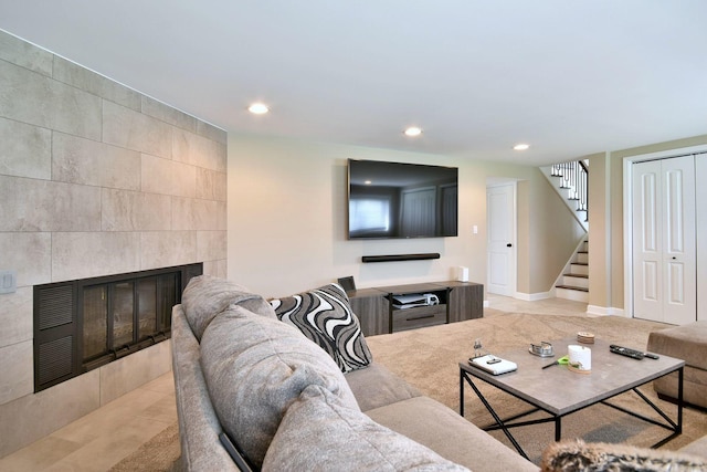 living area featuring baseboards, stairway, recessed lighting, a tile fireplace, and light tile patterned floors